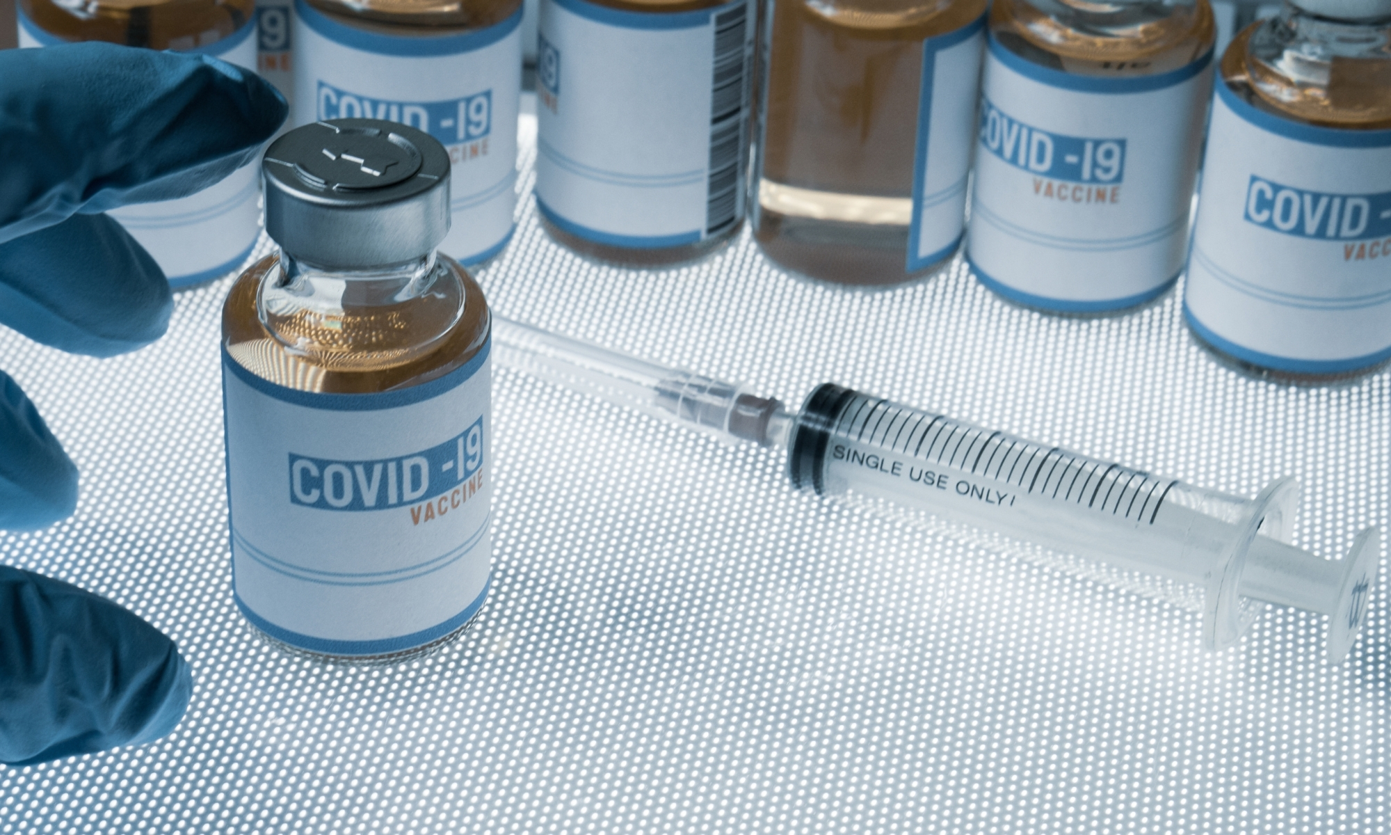 Image of COVID-19 vaccine and needle.